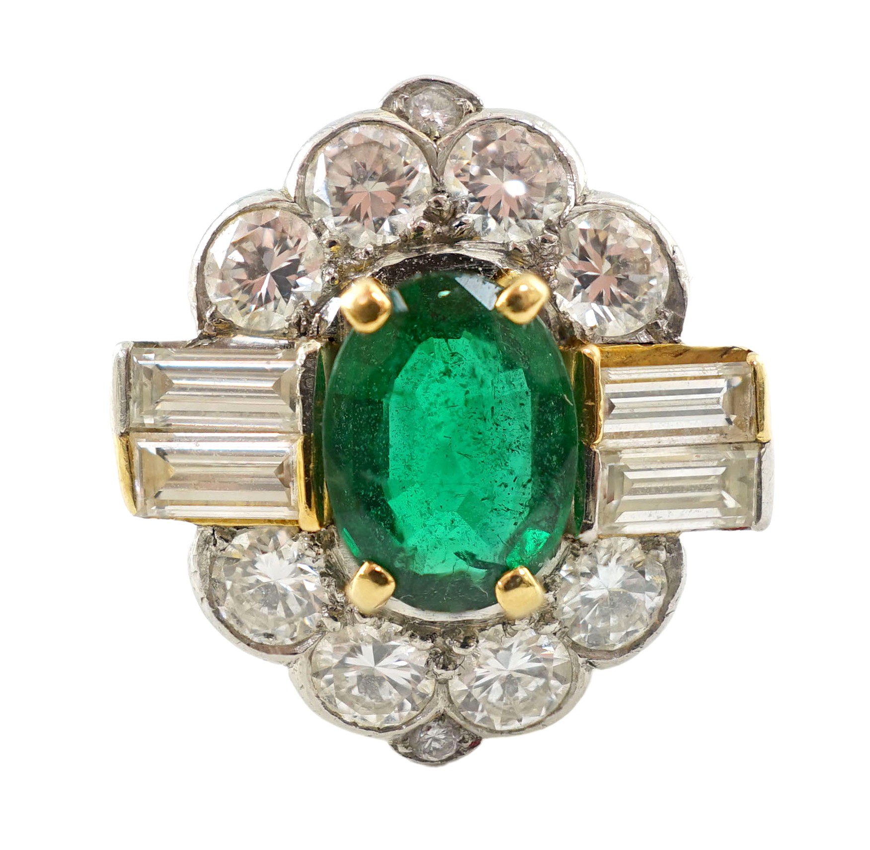 A modern platinum, oval cut emerald and baguette and round cut diamond set cluster ring